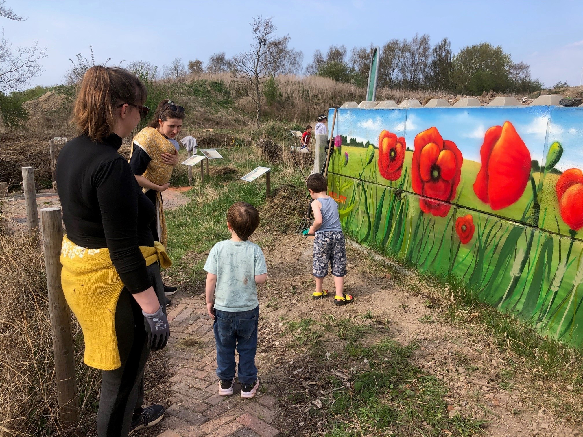Børn og voksne der er i gang med at luge på GenGROstationen i Fårevejle